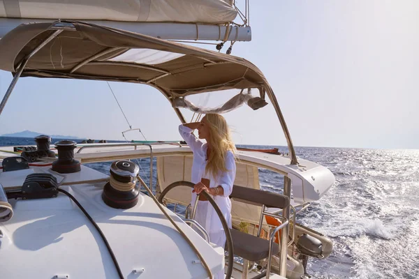 beautiful woman standing on yacht captains bridge at sunny summer day.