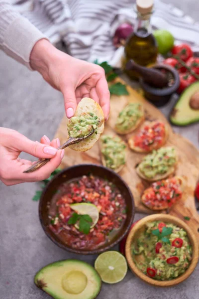 女性作るおいしいサルサとGuacamole Bruschetta軽食で国内キッチン — ストック写真