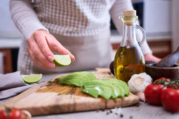 Woman Squeeze Fresh Lime Juice Sliced Avocado Wooden Cutting Board — Fotografia de Stock