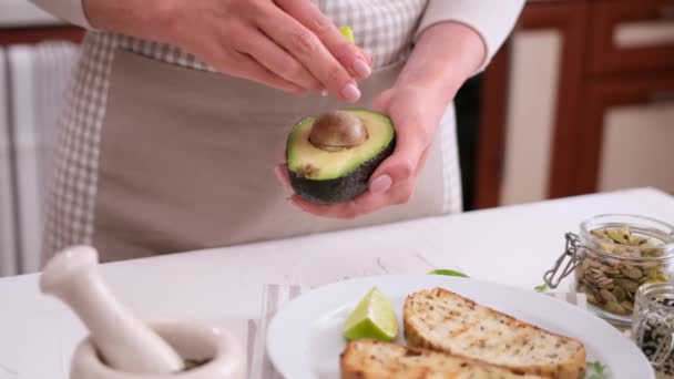 Woman Squeezing Fresh Lime Juice Halved Avocado Fruit — Stok Video