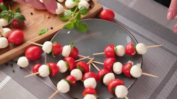 Putting Caprese Canapes Cherry Tomatoes Mozzarella Cheese Balls Plate — Stockvideo
