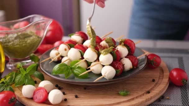 Pouring Pesto Sauce Caprese Canapes Cherry Tomatoes Mozzarella Cheese Balls — Stockvideo