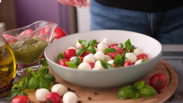 Salting Caprese Salad Mozzarella Cheese Balls Sliced Cherry Tomatoes Basil — Stockvideo