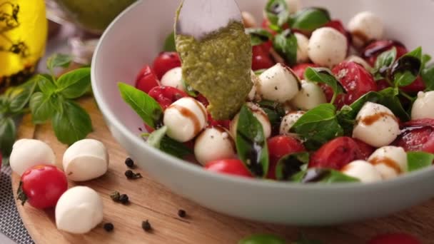 Pouring Pesto Sauce Caprese Salad Cherry Tomatoes Mozzarella Cheese Balls — ストック動画