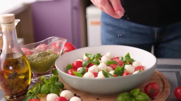 Salting Caprese Salad Mozzarella Cheese Balls Sliced Cherry Tomatoes Basil — Vídeo de Stock