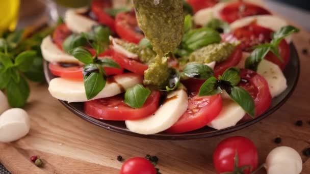 Pouring Pesto Sauce Caprese Salad Cherry Tomatoes Mozzarella Cheese Balls — Vídeos de Stock