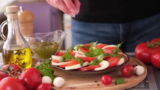 Salting Caprese Salad Mozzarella Cheese Balls Sliced Cherry Tomatoes Basil — Vídeos de Stock