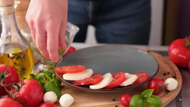 Making Caprese Salad Putting Sliced Tomatoes Mozzarella Plate — стоковое видео