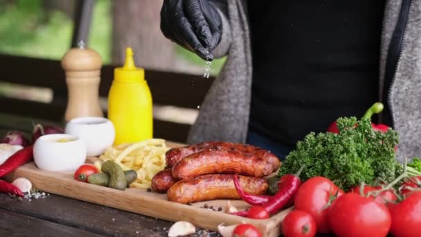 Salting Tasty Grilled Sausages Wooden Serving Board French Fries Sauces — Stockvideo