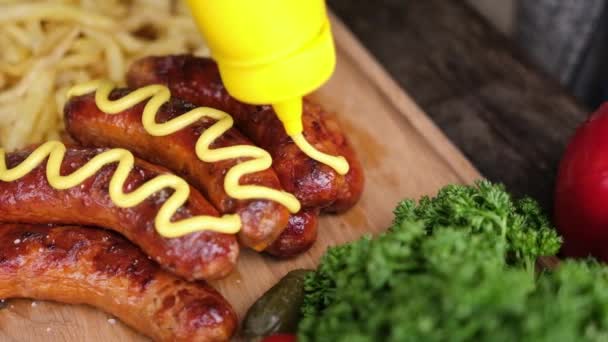 Pouring Mustard Sauce Tasty Grilled Sausages Wooden Serving Board French — Vídeos de Stock