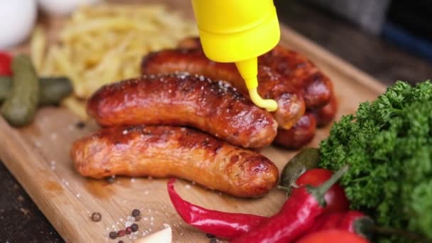 Pouring Mustard Sauce Tasty Grilled Sausages Wooden Serving Board French — Stock videók
