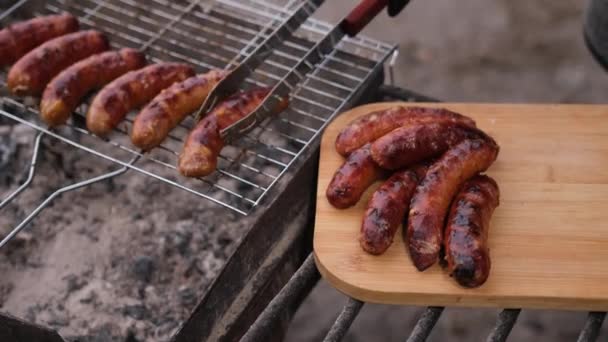 Putting Tasty Grilled Sausages Charcoal Grill Grate Wooden Board — Vídeo de Stock