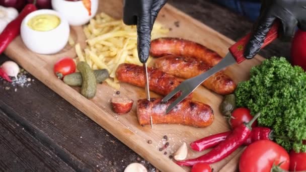 Slicing Tasty Grilled Sausage Wooden Serving Board French Fries Sauces — Stockvideo