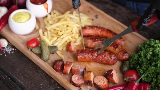 Slicing Tasty Grilled Sausage Wooden Serving Board French Fries Sauces — Vídeos de Stock