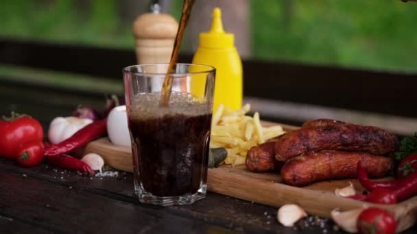Pouring Soda Drink Glass Tasty Grilled Sausages Background — Video