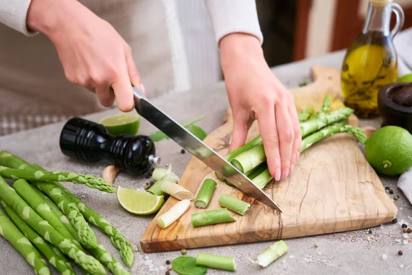 Woman Cutting Green Asparagus Wooden Cutting Board Kitchen Table — Fotografia de Stock