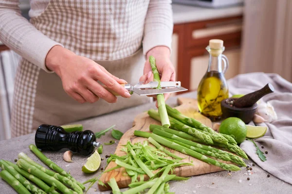 Woman Peeling Green Asparagus Wooden Cutting Board Kitchen Table — Fotografia de Stock