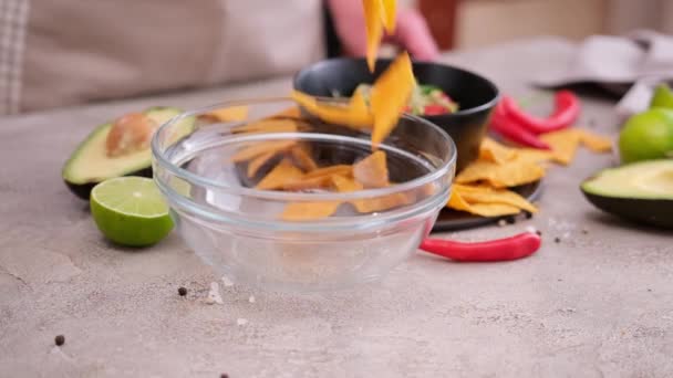 Nachos Chips Falling Glass Bowl Guacamole Dip Sauce Background — Stockvideo