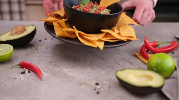 Woman Puts Nachos Chips Freshly Made Guacamole Table — Stockvideo