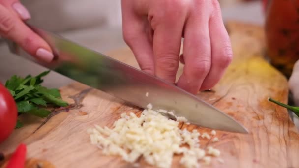 Woman Slices Garlic Kitchen Board Using Knife — Stock video