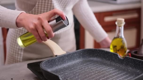 Γυναίκα Ψεκάζει Μαγείρεμα Του Ελαιολάδου Στο Τηγάνι — Αρχείο Βίντεο