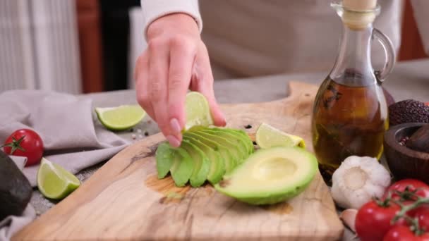 Woman Squeezing Fresh Lime Juice Sliced Fresh Avocado Fruit — Stock Video