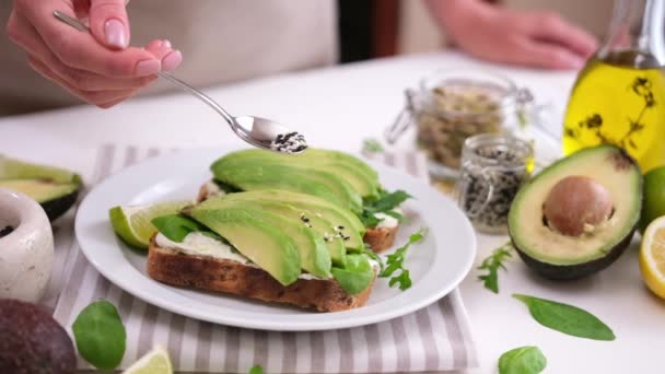 Woman Sprinkles Soft Cheese Avocado Sandwich Sesame Seeds — Vídeo de Stock