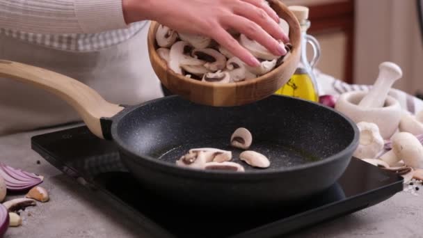 Woman Pouring Sliced Chopped Champignon Mushrooms Frying Pan — стоковое видео