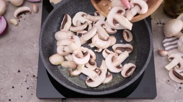 Woman Pouring Sliced Chopped Champignon Mushrooms Frying Pan — стоковое видео