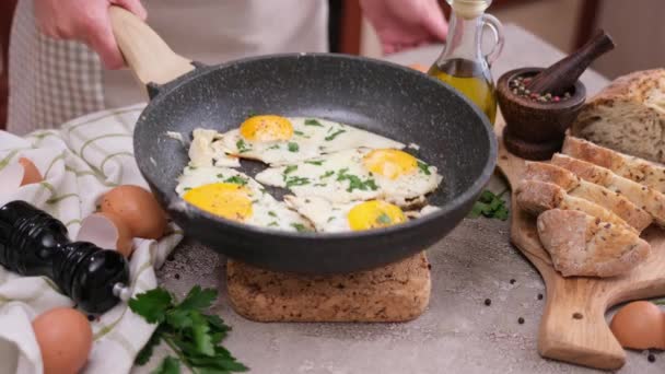 Mujer Pone Sartén Con Huevos Fritos Mesa Cocina — Vídeos de Stock