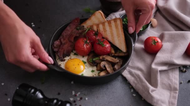 Kobieta Stawia Smaczne Śniadanie Ciemnym Tle Smażony Bekon Jajka Grzyby — Wideo stockowe