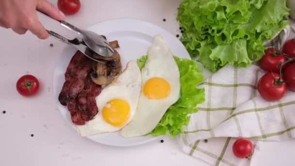Vaření Chutné Snídaně Žena Dává Smažené Houby Slaninu Vejce Bílém — Stock video