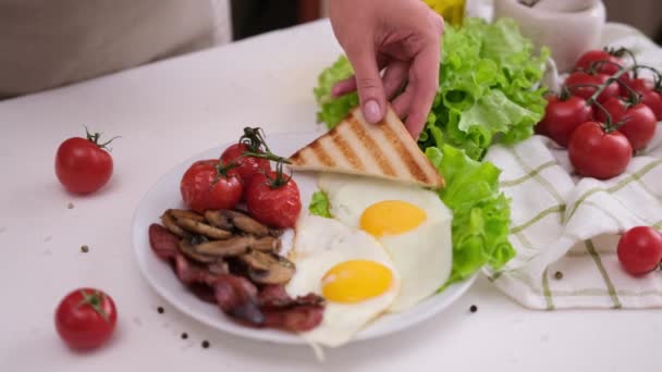 식사를 맛있게 토마토 세라믹 접시에 베이컨 달걀에 넣는다 — 비디오