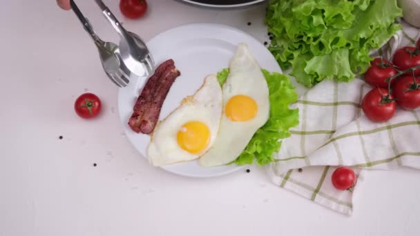 Kvinna Sätter Stekt Bacon Remsor Till Stekt Ägg Vit Keramik — Stockvideo