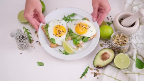 Mujer Pone Tostadas Sanas Recién Hechas Con Aguacate Huevo Frito — Vídeos de Stock