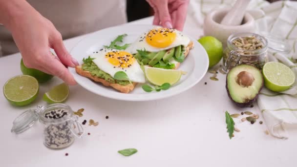 Женщина Кладет Свежеприготовленный Здоровый Тост Авокадо Жареным Яйцом Завтрак — стоковое видео