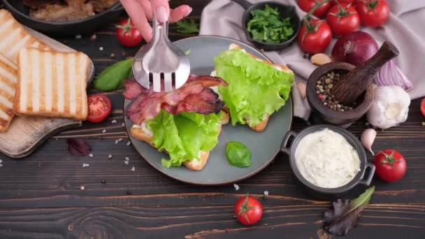 Mujer Poniendo Tocino Frito Una Ensalada Haciendo Sándwich Para Desayuno — Vídeos de Stock