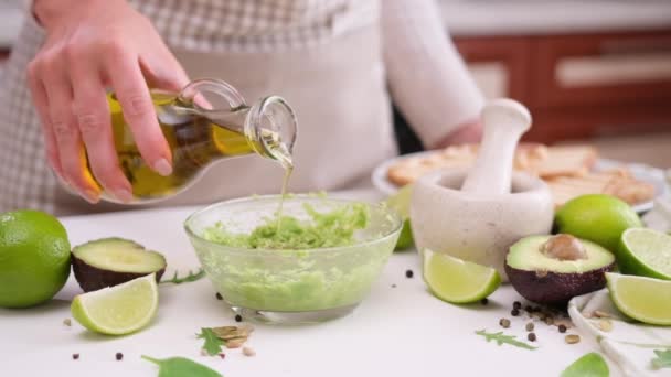 Donna Versando Olio Oliva Nel Purè Avocado Una Ciotola Vetro — Video Stock