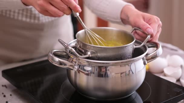 クッキングオランデーズソース 金属製の蒸し鍋に卵黄を混合女性泡立て器で — ストック動画