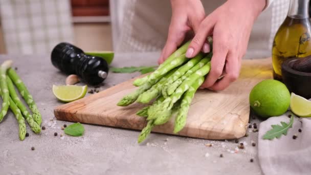 女性置く新鮮な緑有機天然アスパラに木製まな板に国内キッチン — ストック動画