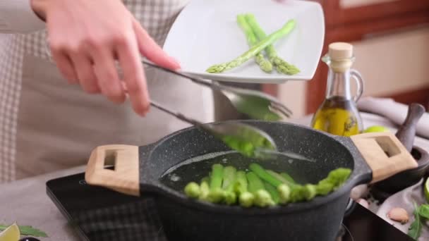 女人把煮好的芦笋从锅里转移到盘子里 — 图库视频影像