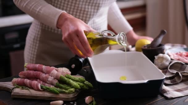 Mulher Derramando Azeite Assadeira Cerâmica Enquanto Cozinhar Espargos Envolto Com — Vídeo de Stock