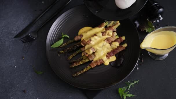 Woman Pouring Hollandaise Sauce Baked Asparagus Wrapped Bacon Plate — Stock Video