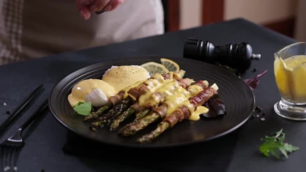 Woman Adding Pepper Spices Baked Asparagus Wrapped Bacon Poached Eggs — Stock Video
