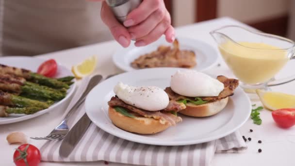 Making Egg Benedict Woman Pours Pepper Poached Egg Grilled Bun — Stock Video
