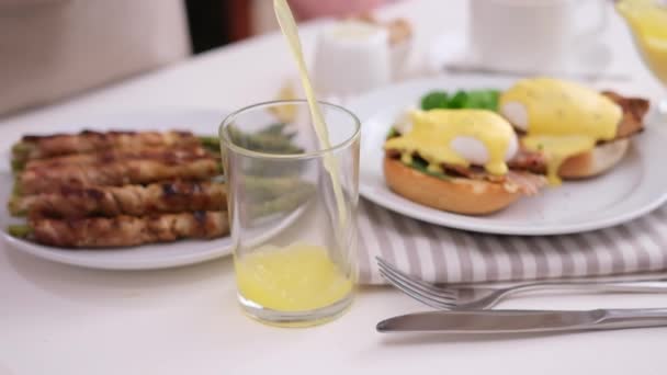 Taze Portakal Suyunu Yumurta Pastırmayla Sarılmış Kuşkonmazlı Bir Masanın Üzerine — Stok video
