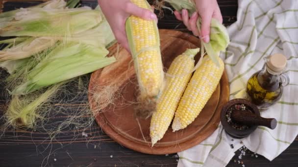 Kobieta Tasowanie Powłoki Kadłub Świeże Kolby Kukurydzy Jej Kuchni — Wideo stockowe