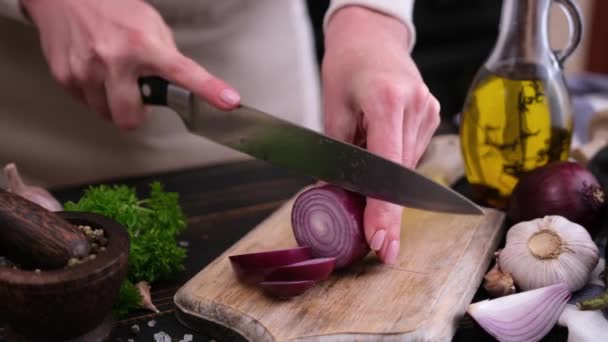 木の板にナイフで赤玉ねぎを切る女 — ストック動画