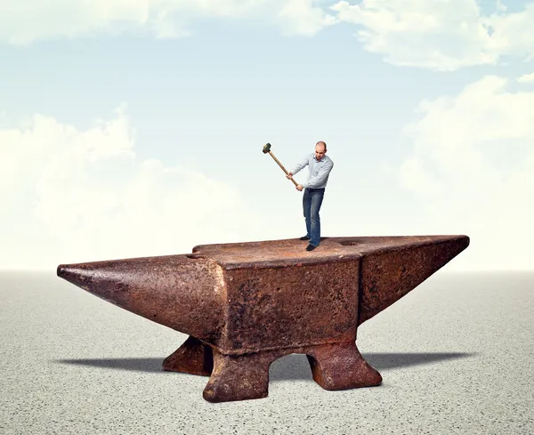 Man on iron anvil — Stock Photo, Image