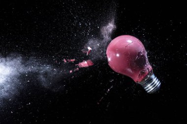 Siyah üzerine kırmızı ampulün patlaması. yüksek hız fotoğrafçılığı.